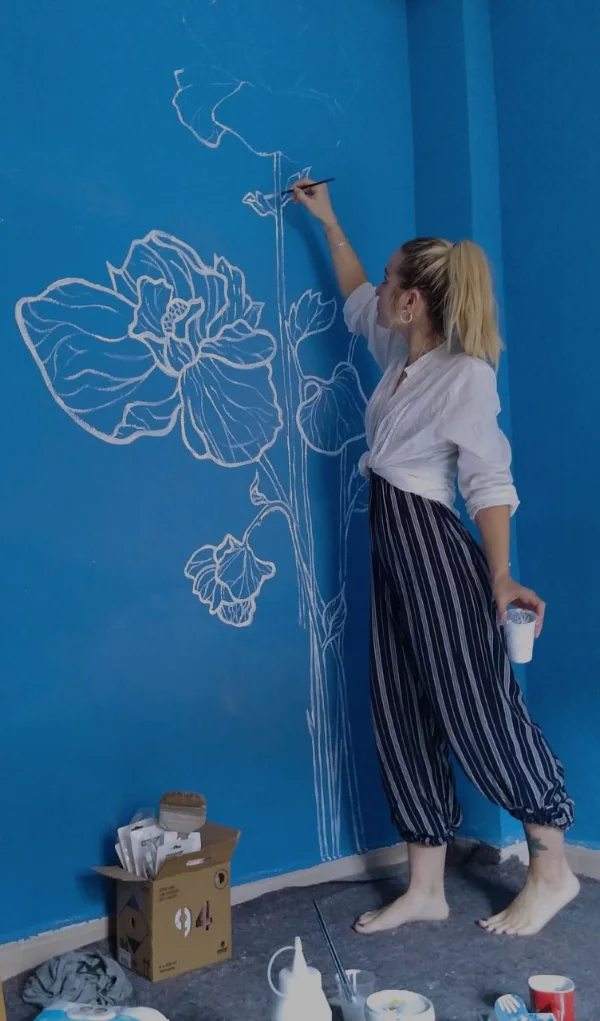 Arte mural con plantas y una pintora